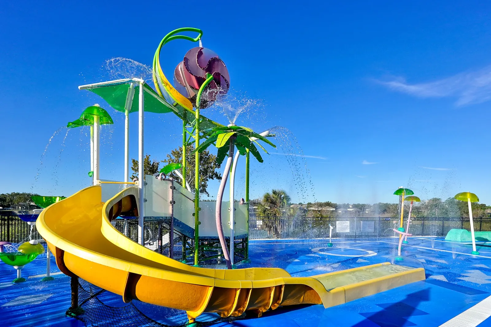 Colorful resort splash pad with water slide and fountains